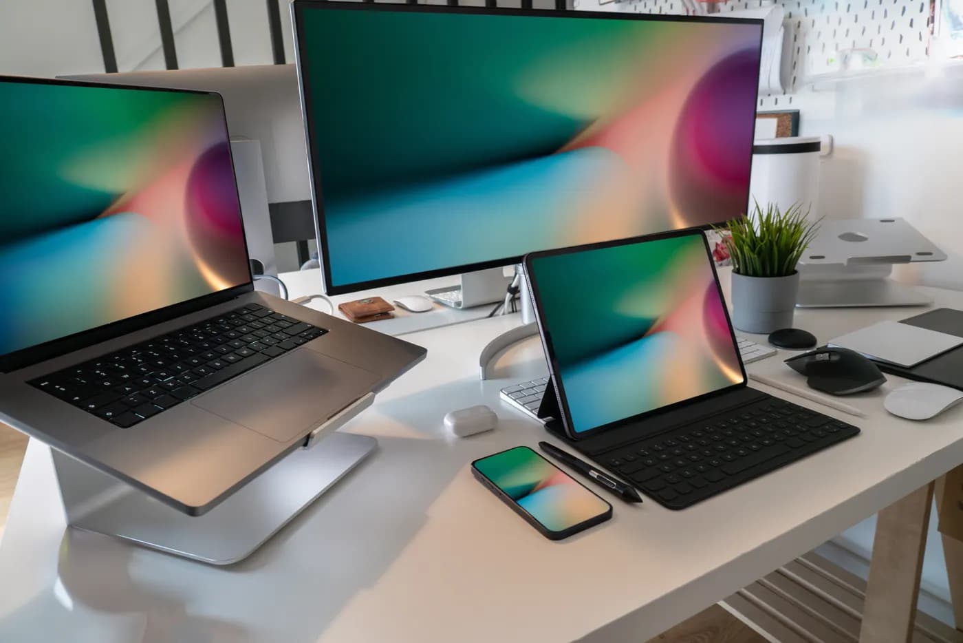 A modern desk with a laptop, monitor, tablet and phone
